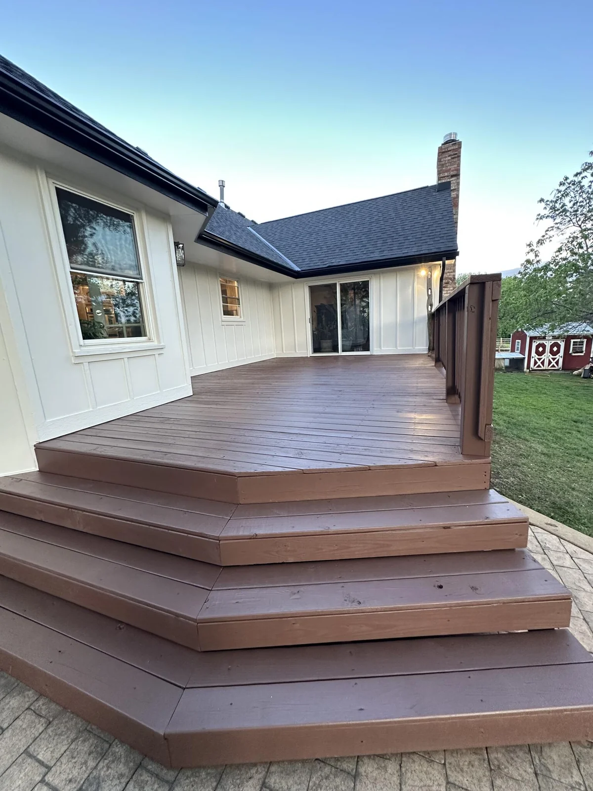 A closer view of the deck, railing, and painted siding